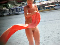 Sexy mature is staying back to the beach voyeur stretching her nude body under the hot rays of the summer sun